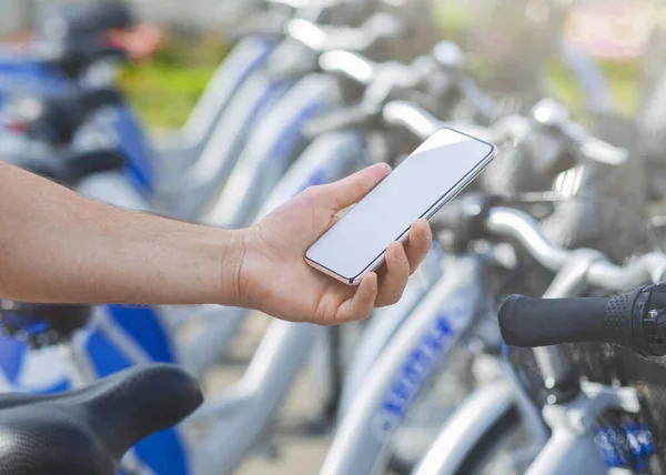 Uomo che utilizza l'app mobile al servizio di bike sharing, mockup — Foto Stock