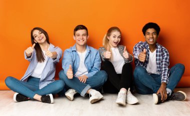 Eğitim konsepti. Mutlu öğrenci takımı baş parmak gösteriyor.