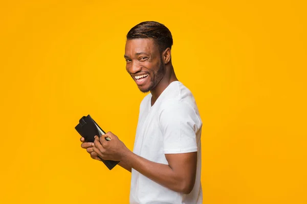 Happy African American Guy Holding Money álló felett sárga háttér — Stock Fotó