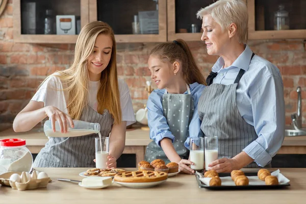Madre premurosa versando latte per la famiglia, pranzando insieme — Foto Stock