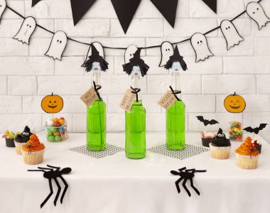 Cadılar Bayramı için martini yeşil kokteyli ve lezzetli kekler.