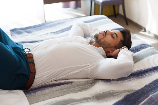 Peaceful businessman resting after hard day on hotel bed — Stock Photo, Image