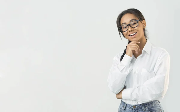 Ευτυχισμένη μαθήτρια που φοράει λευκό πουκάμισο και αγγίζει το πηγούνι — Φωτογραφία Αρχείου