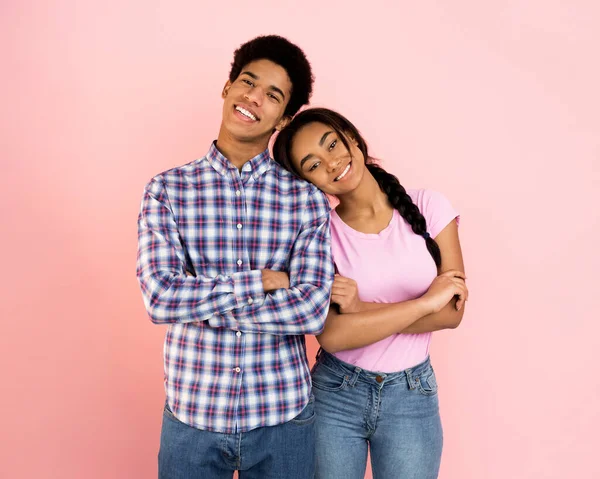 Chica adolescente cariñosa poniendo la cabeza en el hombro masculino, fondo rosa — Foto de Stock