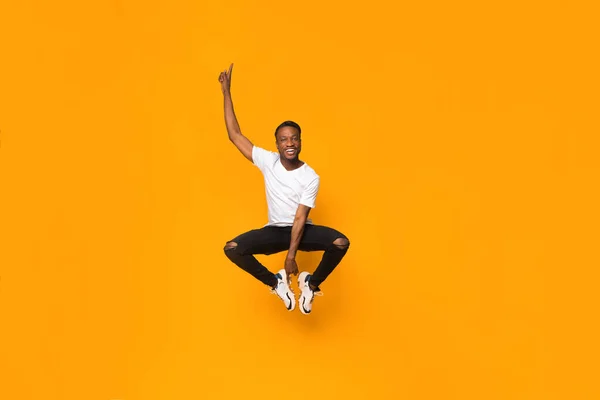 Positiver Afro-Mann springt in die Luft und hat Spaß im Studio — Stockfoto