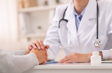 Tanımlanamayan Bayan Doktor, tıbbi randevu sırasında hastayı rahatlatıyor.