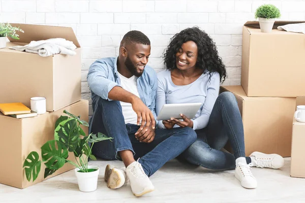 Young woman showing her man on tablet ideas for interior — Stock Photo, Image