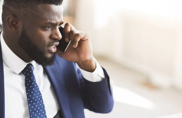 Hombre de negocios furioso hablando por teléfono inteligente con los socios — Foto de Stock