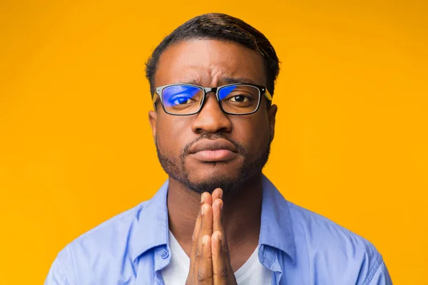 Fekete ember imádkozott nézi a kamera felett álló sárga háttér — Stock Fotó