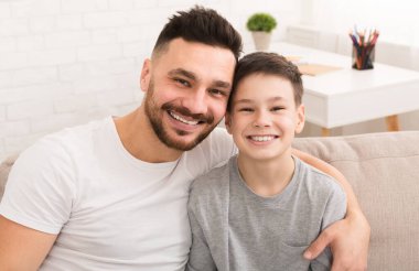 Neşeli baba ve oğul portresi, evde kucaklaşmak.