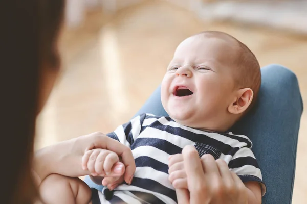 Zbliżenie portret śmiejącego się noworodka leżącego na kolanach matek — Zdjęcie stockowe