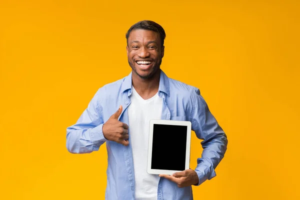 Hombre afroamericano mostrando la pantalla de la tableta que sugiere pulgares hacia arriba, filmación del estudio — Foto de Stock