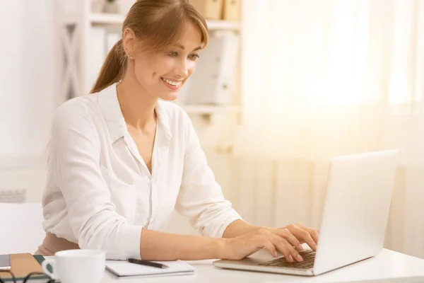 Geschäftsfrau tippt auf Laptop in modernem Büro — Stockfoto