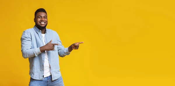 Alegre negro chico apuntando dos dedos a un lado en copia espacio — Foto de Stock