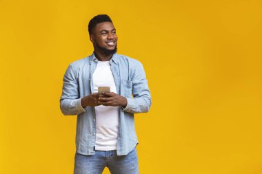 Akıllı telefonu tutan yakışıklı adam fotokopi alanına bakıyor.