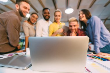 Beyin fırtınası tasarlıyor, dizüstü bilgisayarda yeni fikirleri tartışıyor.