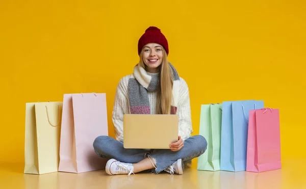 Junges Mädchen in Wintermütze online einkaufen, mit Laptop — Stockfoto