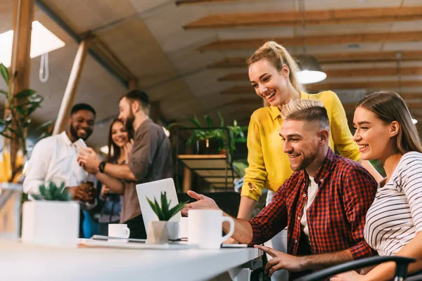 Jonge collega 's werken aan laptop en bespreken nieuw project — Stockfoto