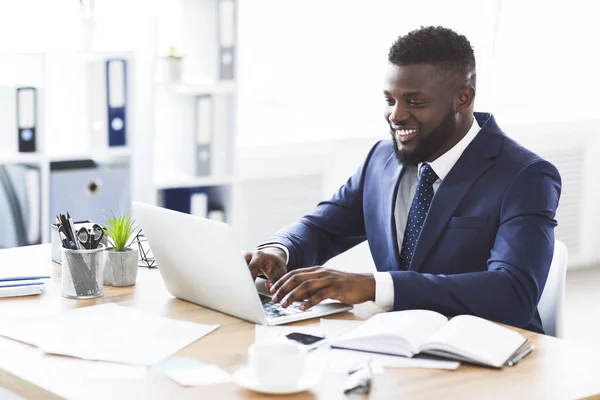 Boldog fiatal üzletember dolgozik laptop az irodában — Stock Fotó