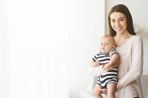 Retrato de madre feliz con adorable bebé en sus manos — Foto de Stock