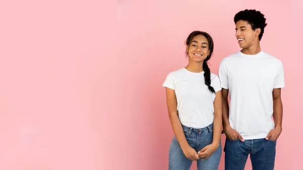 Söt tonåring par poserar på rosa bakgrund med fritt utrymme — Stockfoto