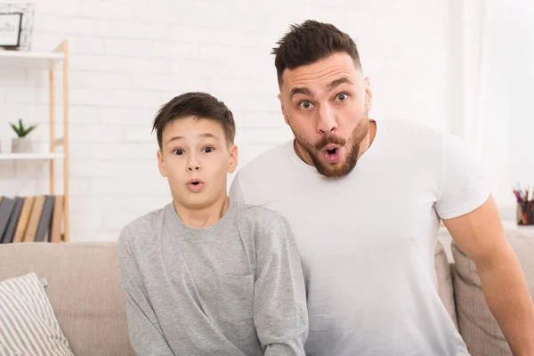 Incrível pai e filho olhando para a câmera com bocas abertas — Fotografia de Stock