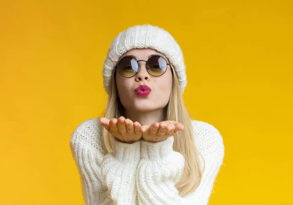 Ung vacker kvinna i vinter hatt och solglasögon blåser kyss — Stockfoto