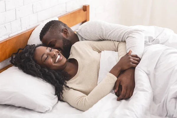 Junges schwarzes Paar wacht morgens im Bett auf — Stockfoto