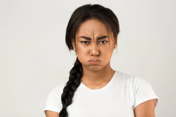 Angry afro girl blowing her cheeks, grey background — ストック写真