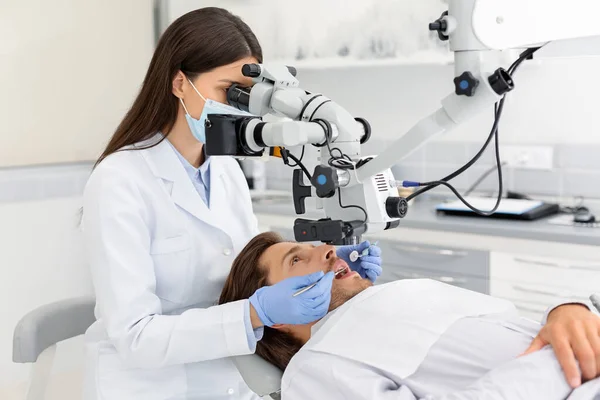 Médico dentista feminino fazendo tratamento no armário moderno — Fotografia de Stock