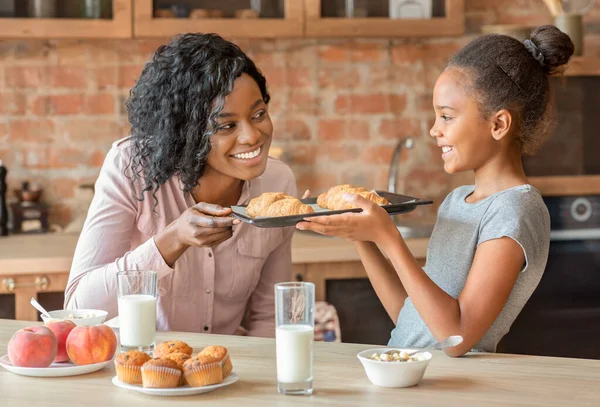 Feliz niña mostrando croissants hechos a sí mismo a mamá — Foto de Stock