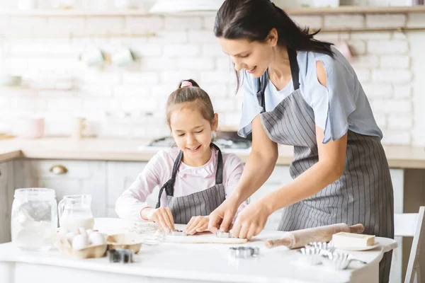 Anya és lánya sütit süt együtt, tésztát présel vágóval — Stock Fotó