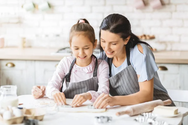 Mutter und Kind schneiden verschiedene Teigformen aus — Stockfoto