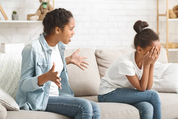 Liten flicka sitter på soffan gråter, slåss med syster — Stockfoto