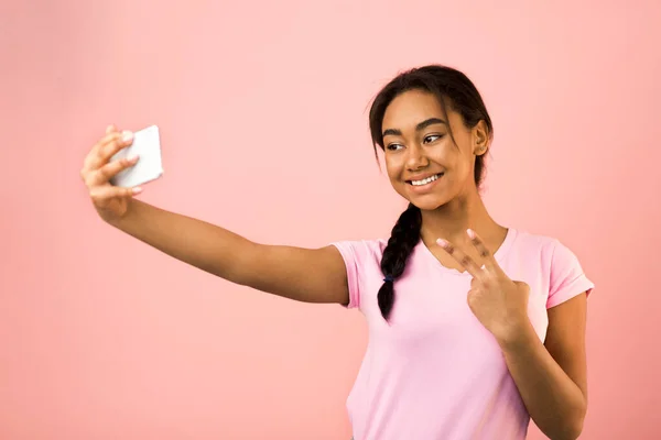 Mutlu kız selfie çekiyor ve barış jesti yapıyor. — Stok fotoğraf