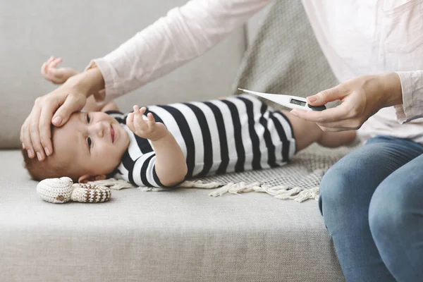 Mère vérifiant la température de son bébé malade — Photo