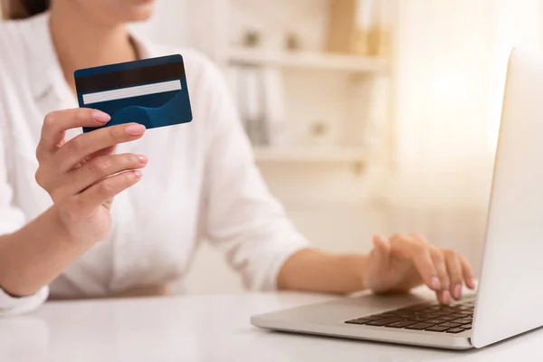 Frau mit Kreditkarte und Laptop im Büro nicht wiederzuerkennen — Stockfoto