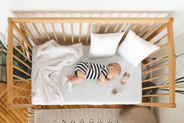 Top view of adorable newborn baby sleeping in wooden crib — Stock Photo, Image
