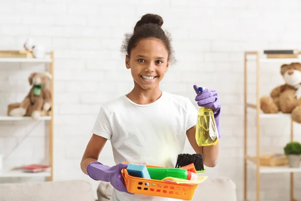 Küçük kız farklı temizlik malzemeleri tutuyor ve gülümsüyor. — Stok fotoğraf