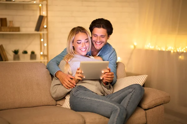 Mutlu genç çift tablet kullanıyor ve eğleniyor.
