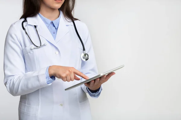 Ireconhecível Lady Doctor Usando Tablet Computador em pé no estúdio, cortado — Fotografia de Stock