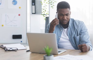 Depresyondaki Afrikalı Amerikalı iş adamı telefonda kötü haberler alıyor.