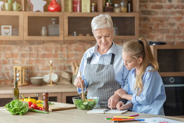 Abuela enseñando a su nieta a cocinar en la cocina — Foto de Stock