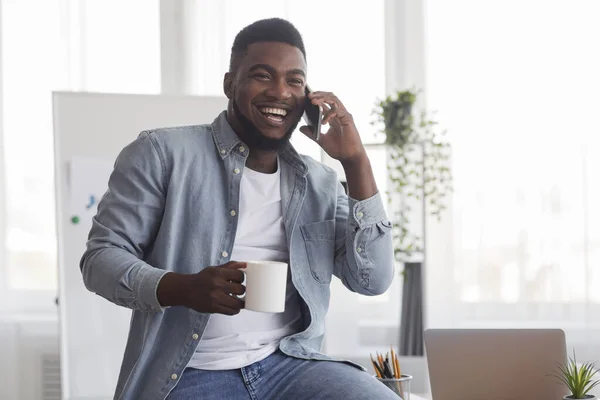 Entrepreneur joyeux parler au téléphone et boire du café au bureau — Photo