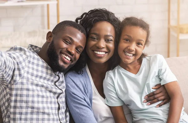 Sonriente hombre negro tomando selfie con su esposa e hija —  Fotos de Stock