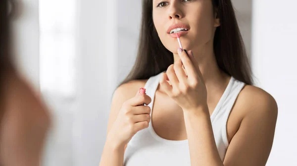 Mulher muito jovem aplicando batom em pé no banheiro, Panorama — Fotografia de Stock