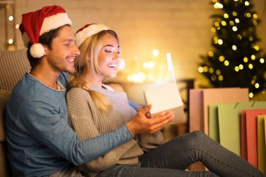 Xmas büyüsü. Sevgili çift Noel hediyesi kutusunu açıyor.