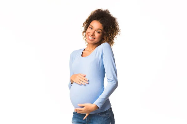 Αφρο-αμερικανική έγκυος γυναίκα χαϊδεύει την κοιλιά της και χαμογελά — Φωτογραφία Αρχείου