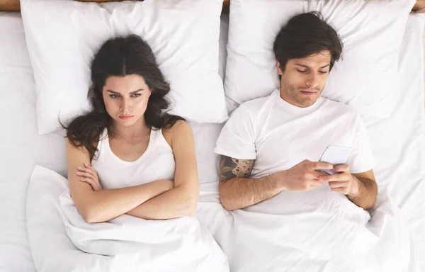 Hombre adicto jugando videojuego en el teléfono celular en la cama — Foto de Stock