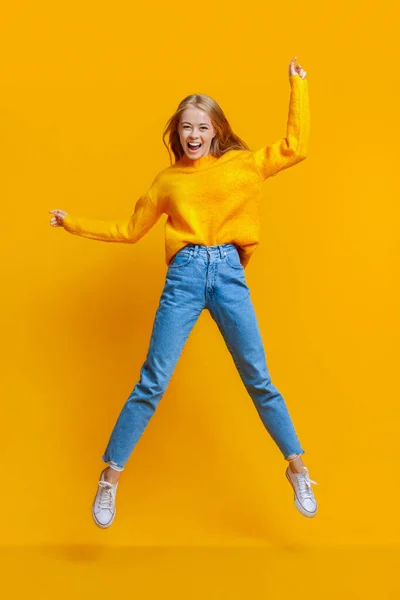 Euforisch tiener meisje springen in de lucht met de handen omhoog — Stockfoto